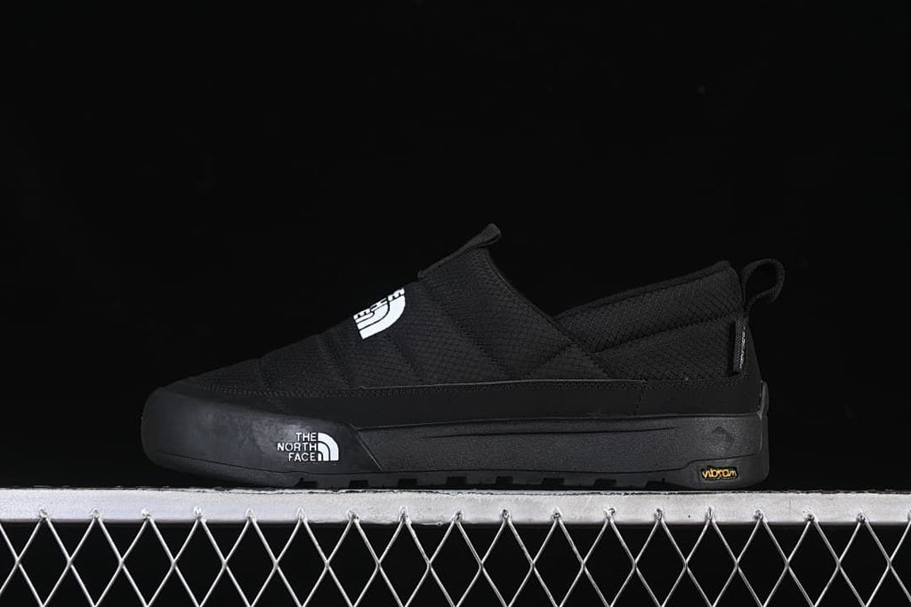 Side view of a black The North Face slip-on shoe with a thick sole