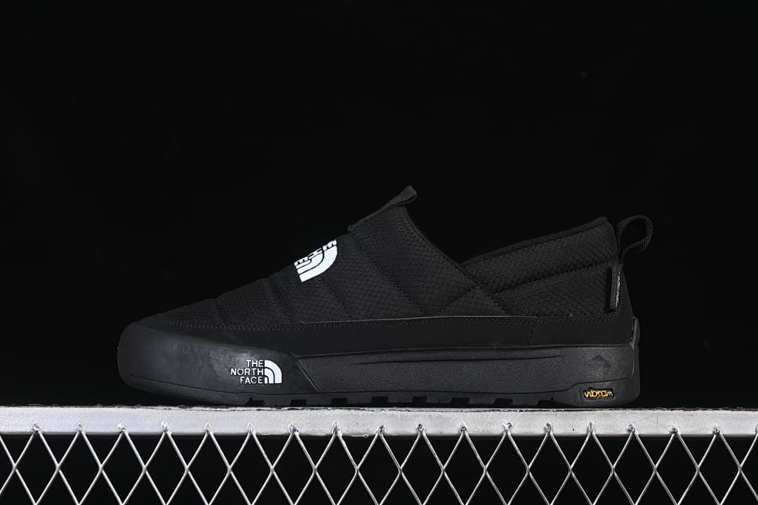 Side view of a black The North Face slip-on shoe with a thick sole