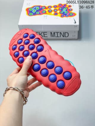 Underside of the red Nike Mind 001 mule showing raised circular sole pods.