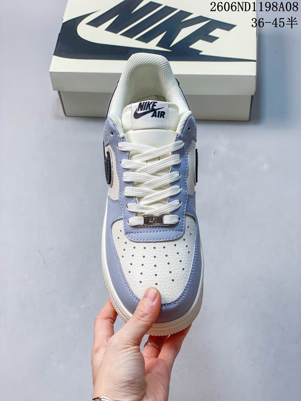 Top view of the sneaker showing white laces, a perforated off-white toe, and light-blue overlays; image overlay shows code 2606ND1198A08 and size range 36–45.5.