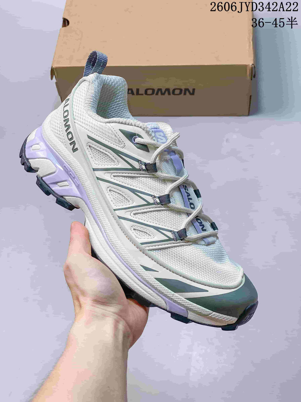 White Salomon mesh sneaker with dark green accents, shown from the side