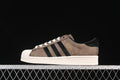 Side view of brown and black adidas Superstar sneakers with an off-white shell toe and sole