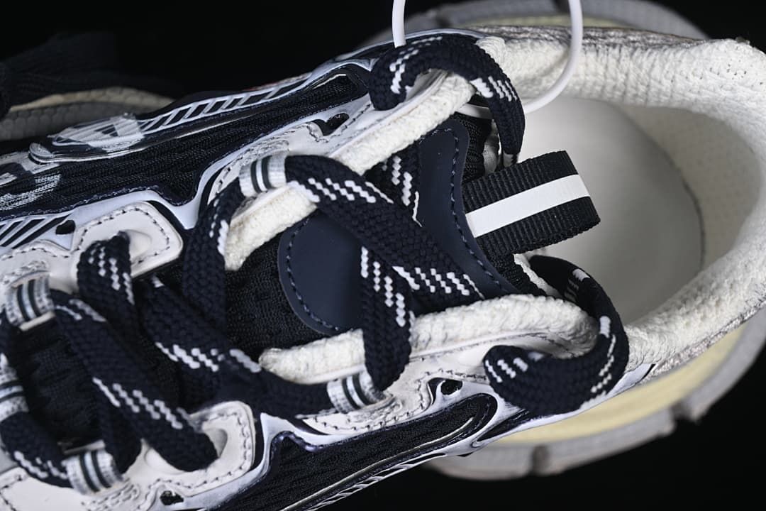 Top-side close-up of the sneaker's laces, collar, and layered upper.
