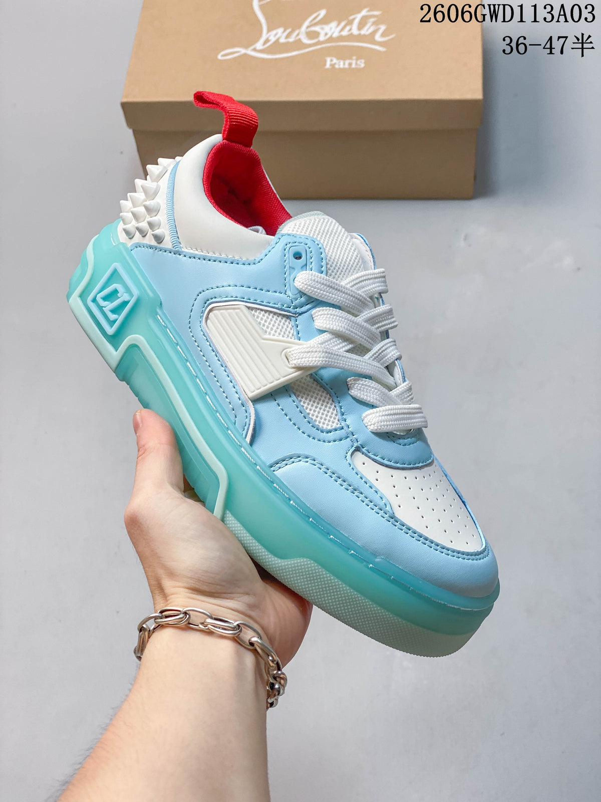 Angled side view showing the blue and white upper, studded heel, and turquoise-colored sole