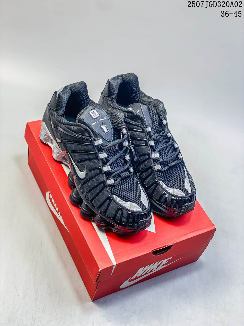Black and silver Nike Shox TL sneakers displayed on a red shoe box
