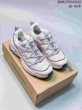 Pair of white and pale lavender Salomon low-top sneakers on a branded shoebox