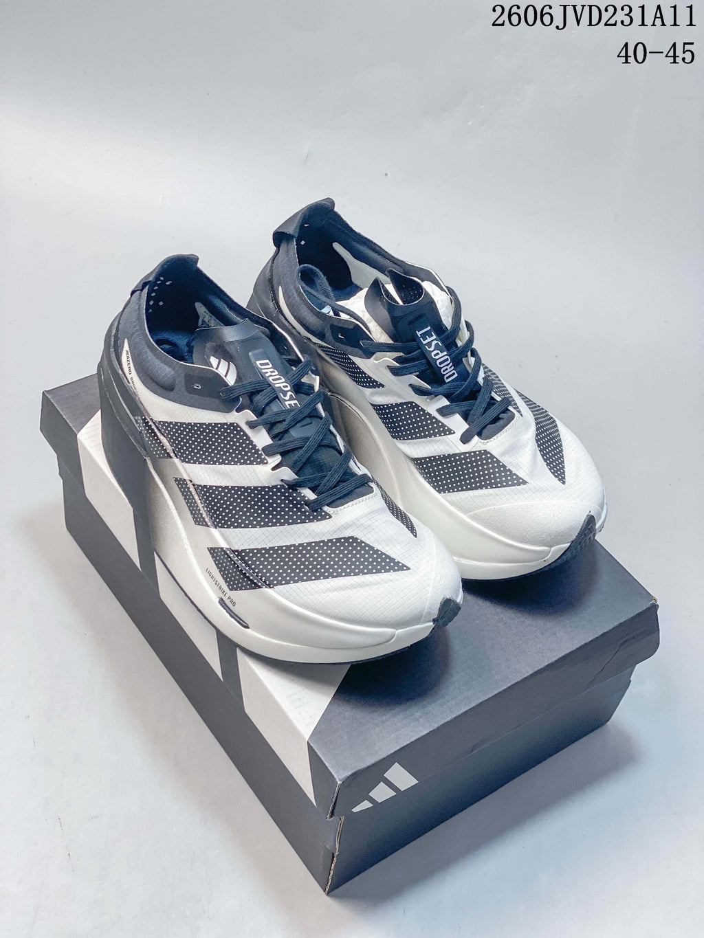 Pair of white and gray Adidas Adizero Dropset Elite shoes on a branded box