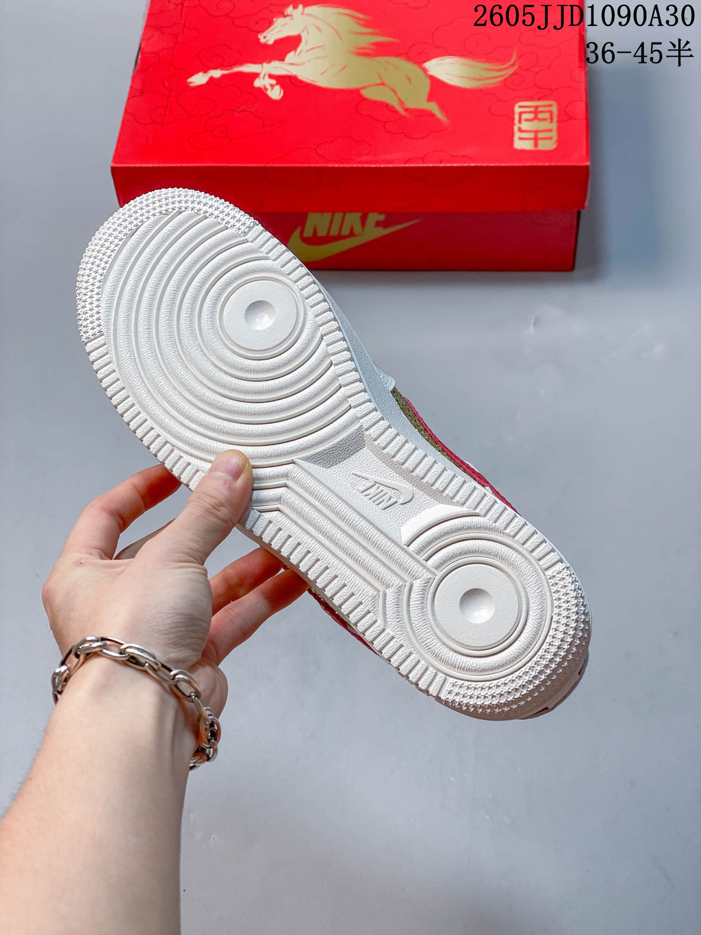 Underside of a white sneaker showing a circular tread pattern