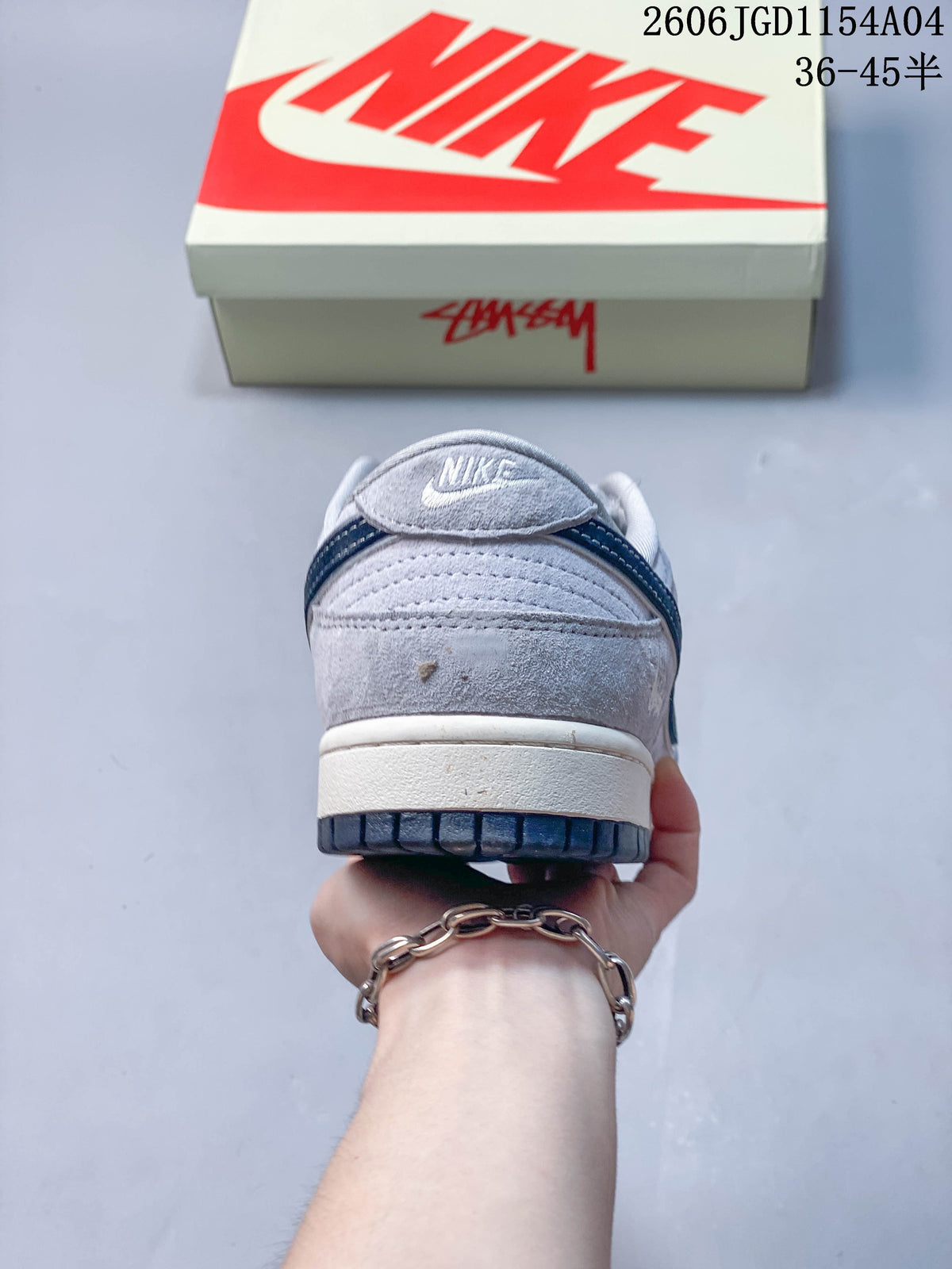 Rear view of a grey Nike SB Dunk Low style sneaker showing the heel and navy outsole