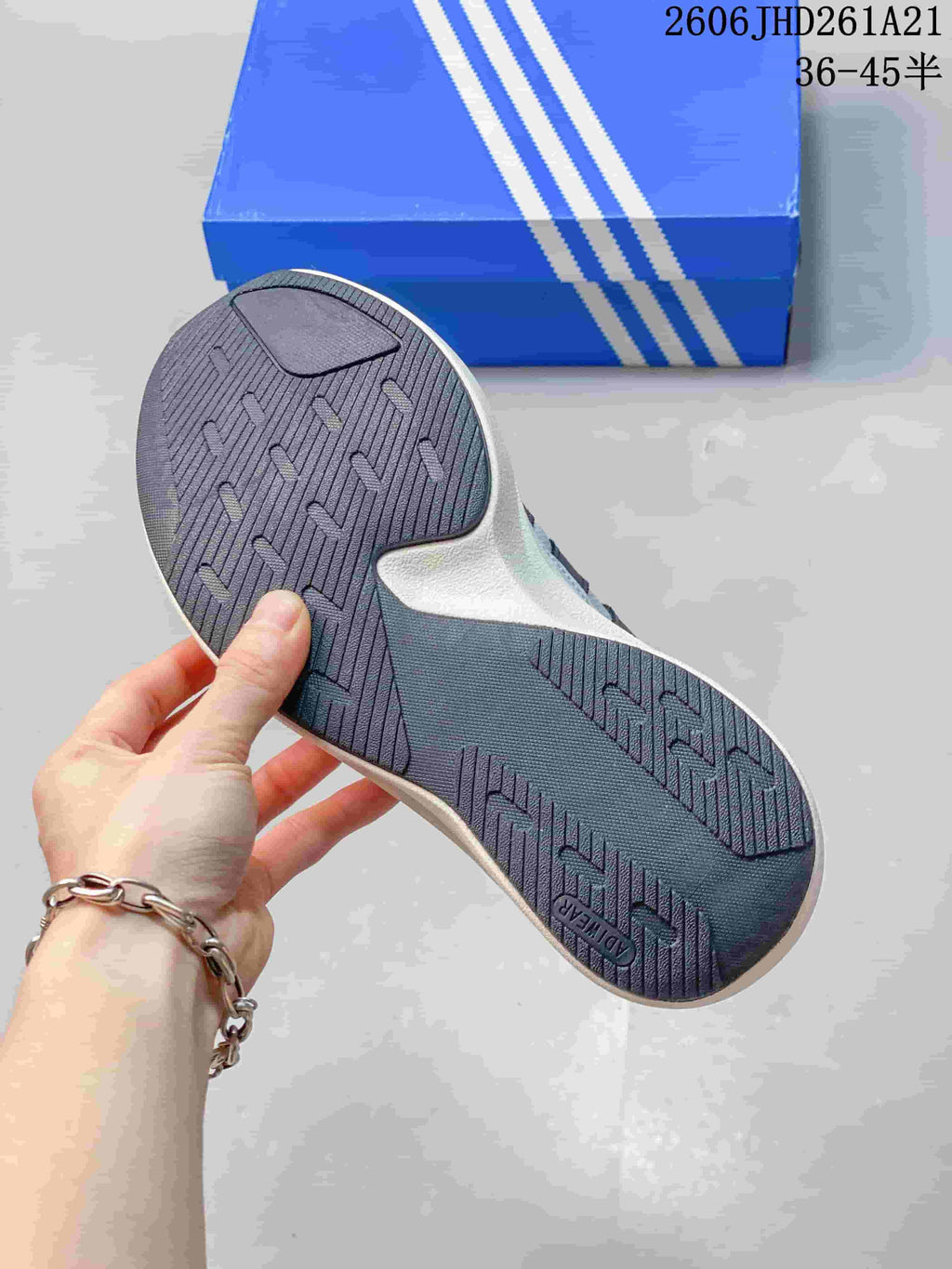 Close-up of the dark patterned outsole on a grey adidas Originals sneaker