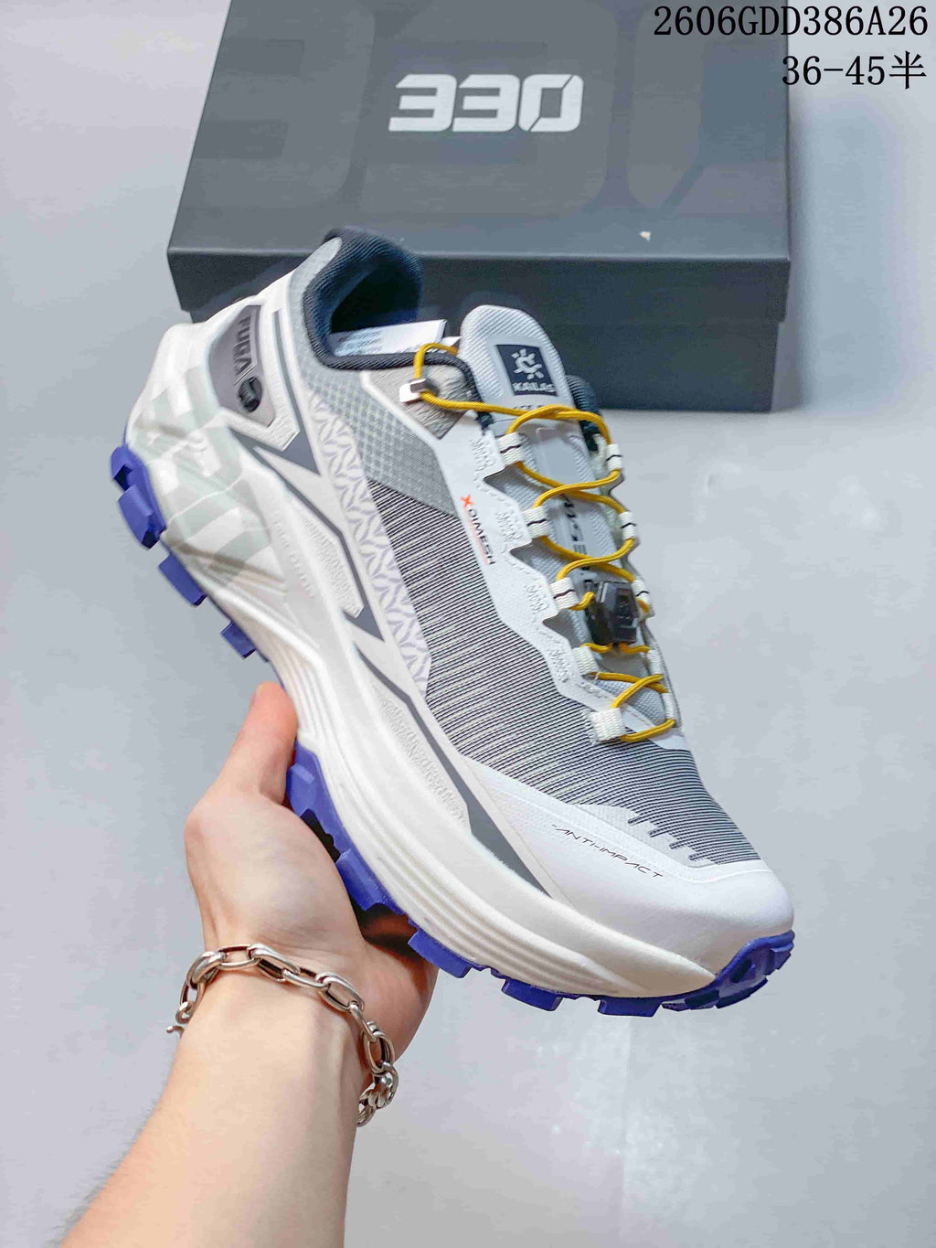 Side view of a gray and white KAILAS FUGA EX330 shoe with yellow laces and purple outsole lugs