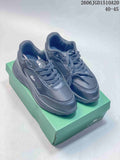 Pair of dark navy Lacoste low-top sneakers displayed on a green shoebox.