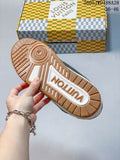 Outsole view of the white and green low-top sneaker beside a patterned Louis Vuitton box