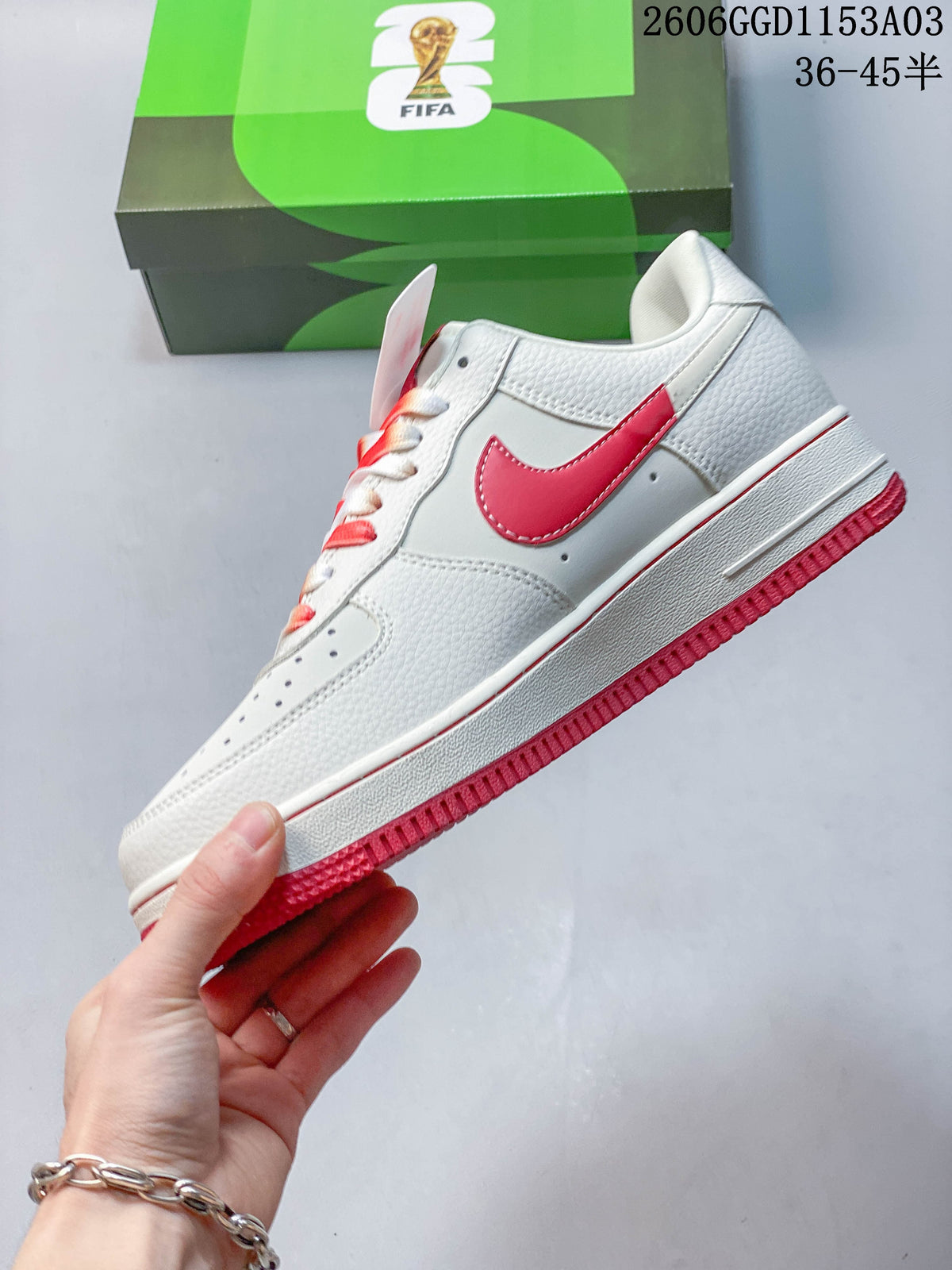 Side view of a white low-top sneaker with a red Swoosh and outsole.