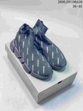 Dark gray sock-style sneakers with repeated Balenciaga branding and segmented sole, pictured on a box.
