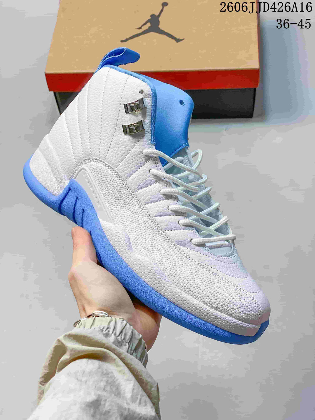 Close-up of a white and blue high-top sneaker showing the textured upper, laces and metallic side hardware