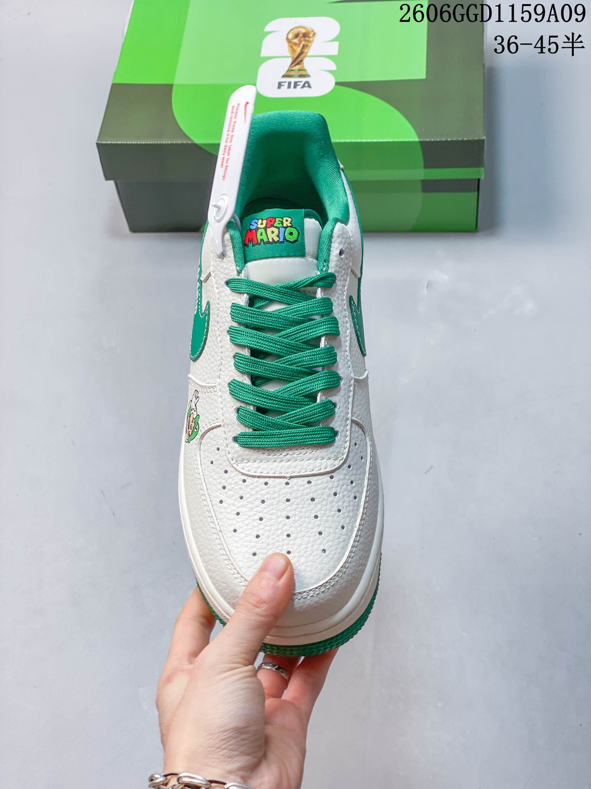Top view of a white sneaker with green laces and Super Mario tongue graphic