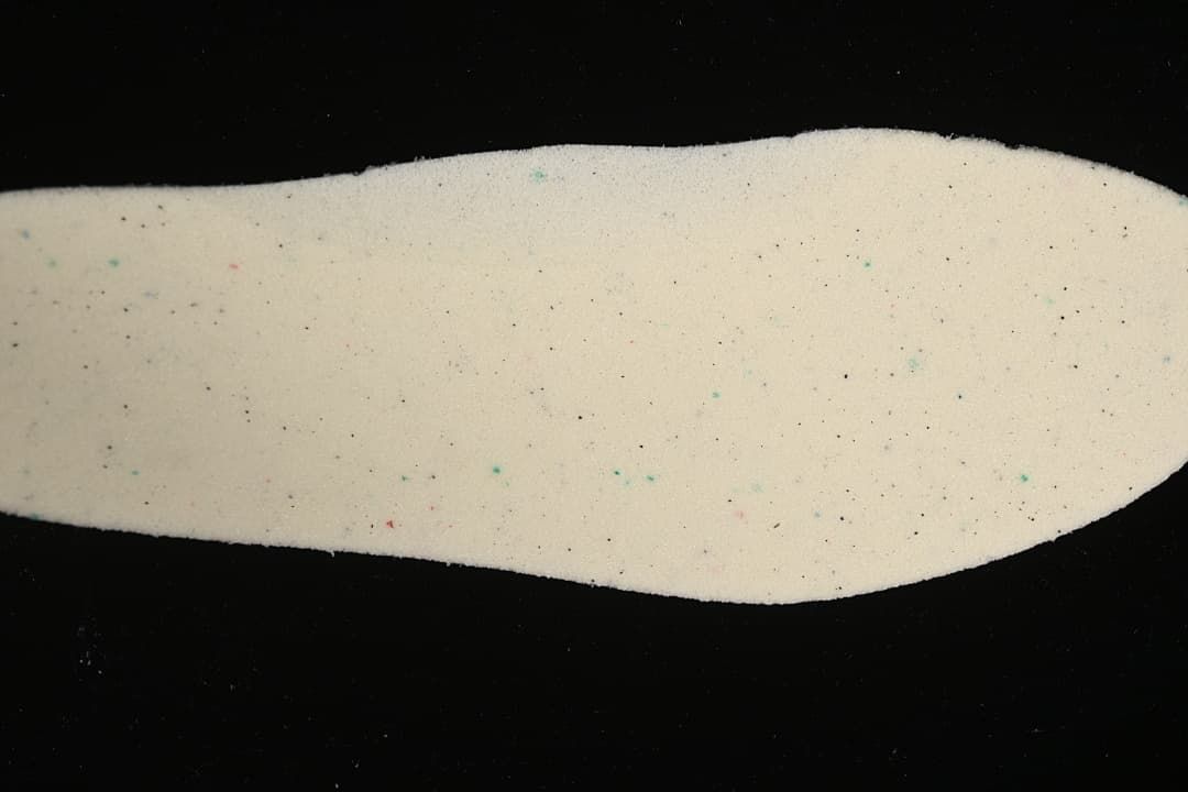 Light-colored shoe insole shown against a dark background.