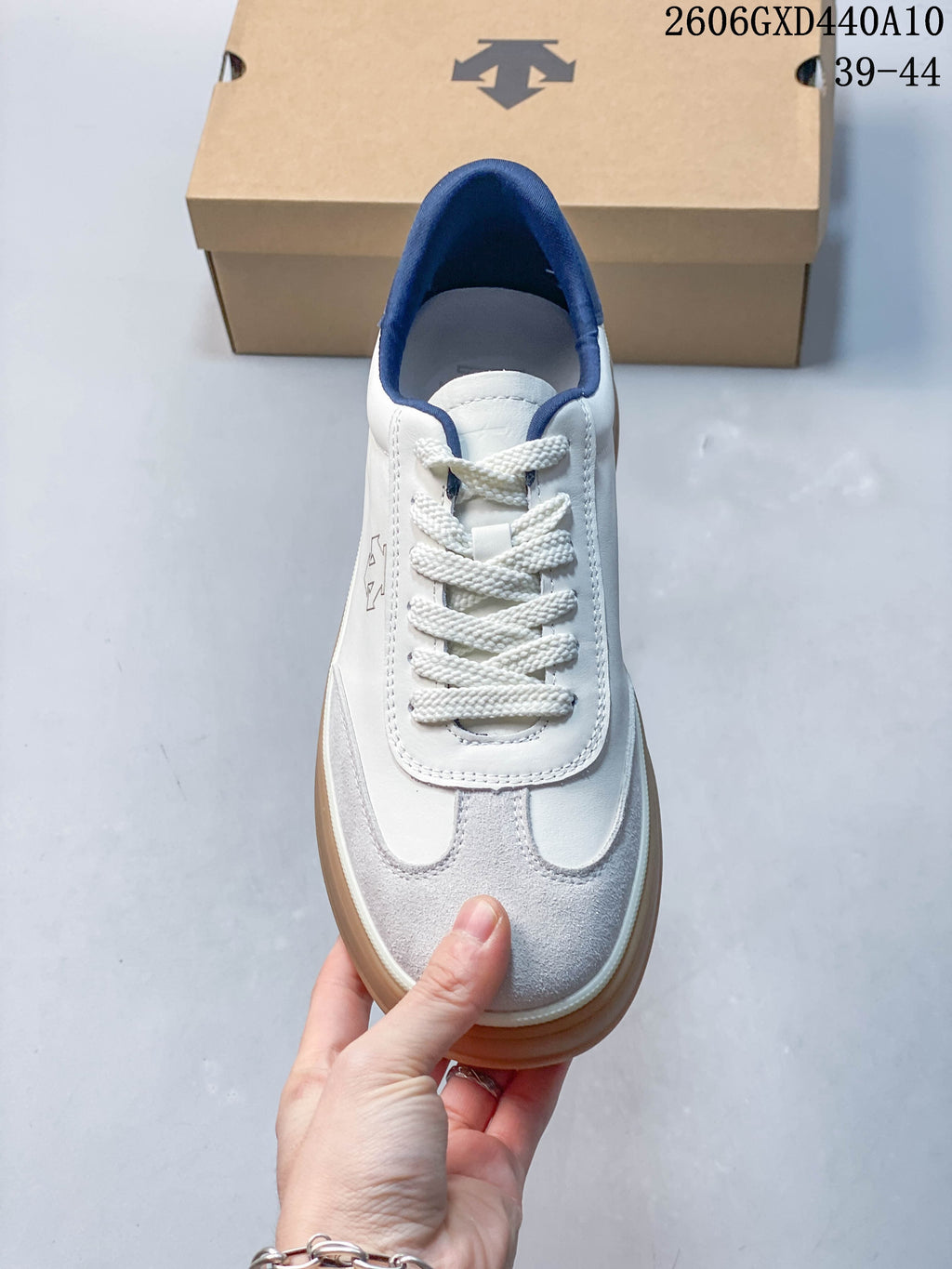 Top view showing the sneaker's white laces, gray T-toe panels, and navy lining.