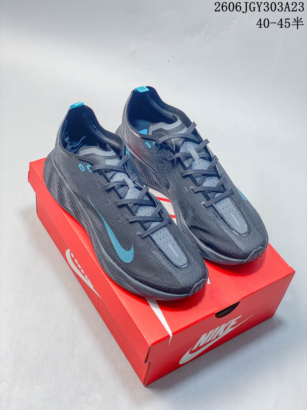 Pair of charcoal gray Nike Ava Rover low-top running shoes with blue accents on a red shoe box.