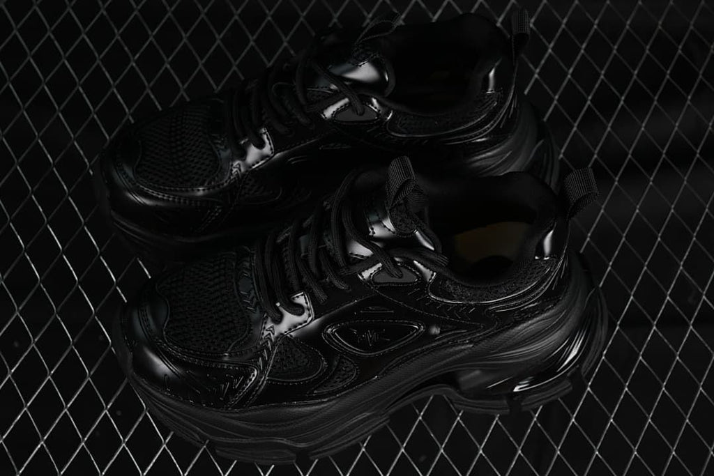 Pair of black chunky sneakers photographed from above at an angle.