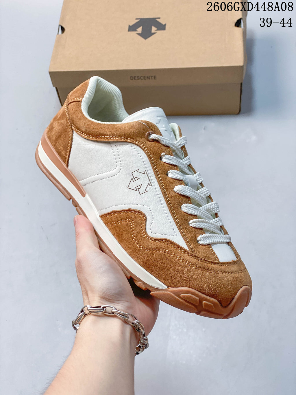 Angled side view of the brown and white DESCENTE sneaker
