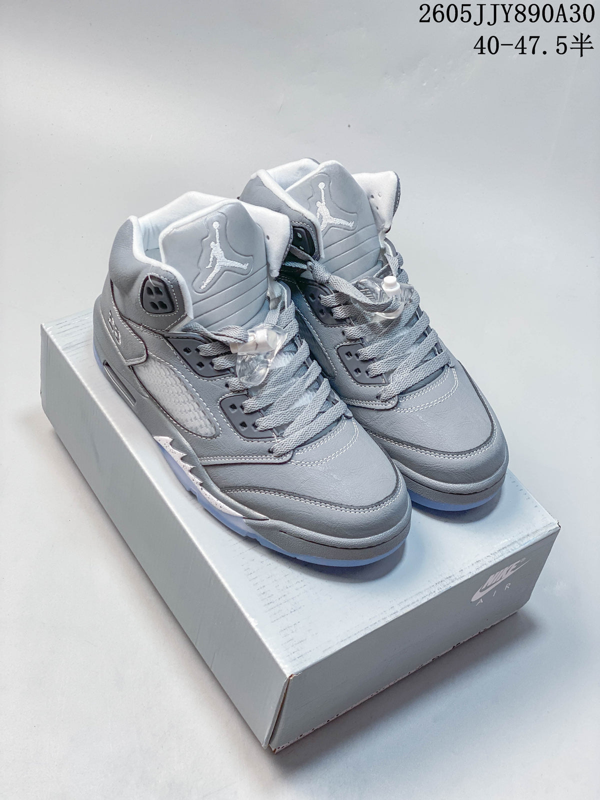 Pair of grey Jordan Air Jordan 5 Retro high-top sneakers on a shoebox