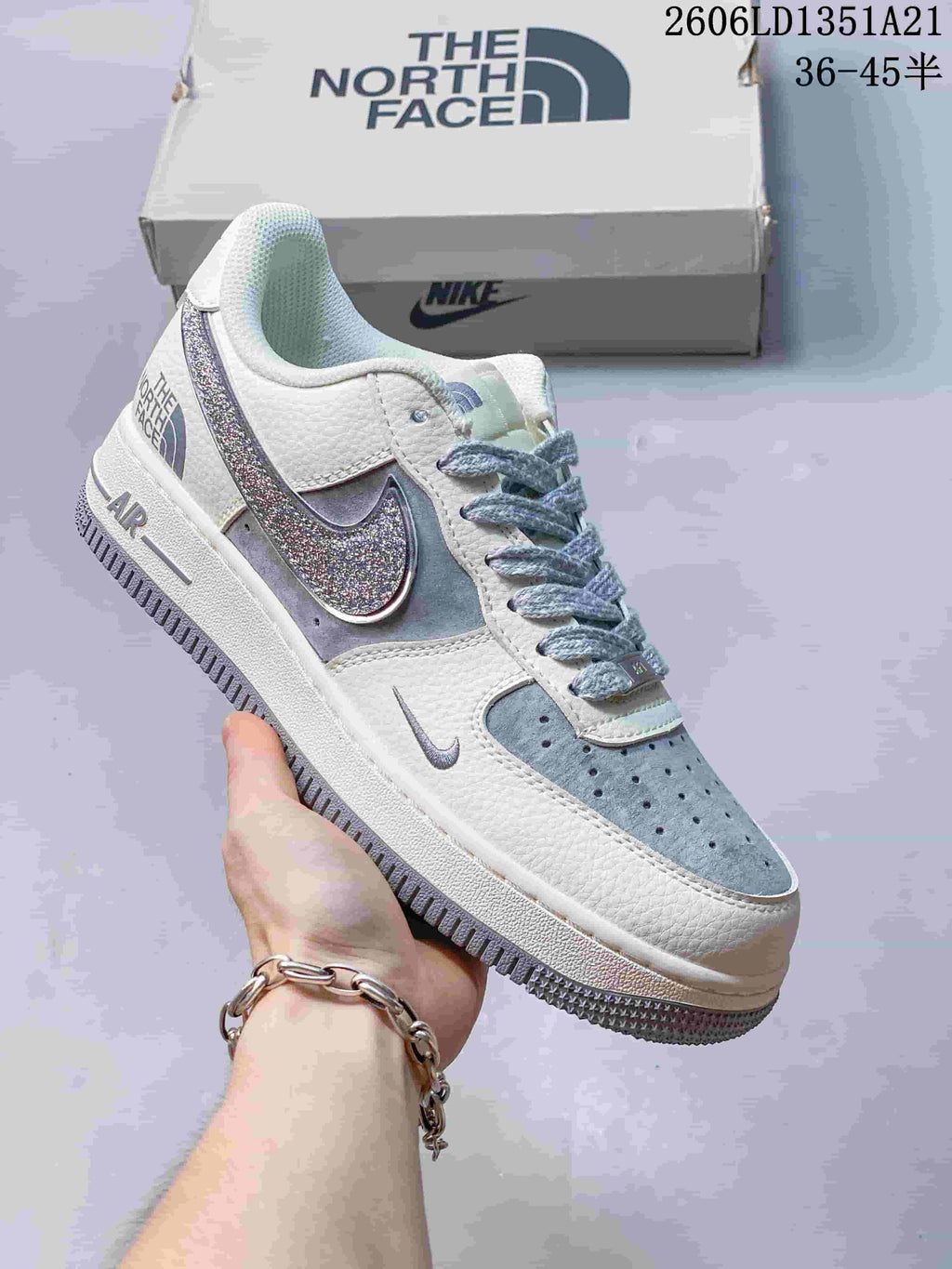 White low-top sneaker with silver glitter Swoosh and pale blue-gray accents