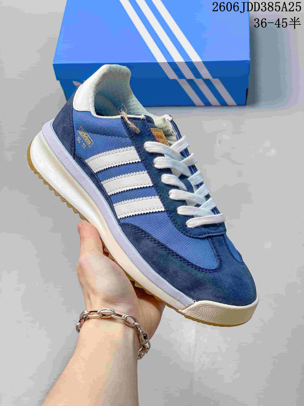 Angled side view of the blue sneaker with white stripes and navy overlays.