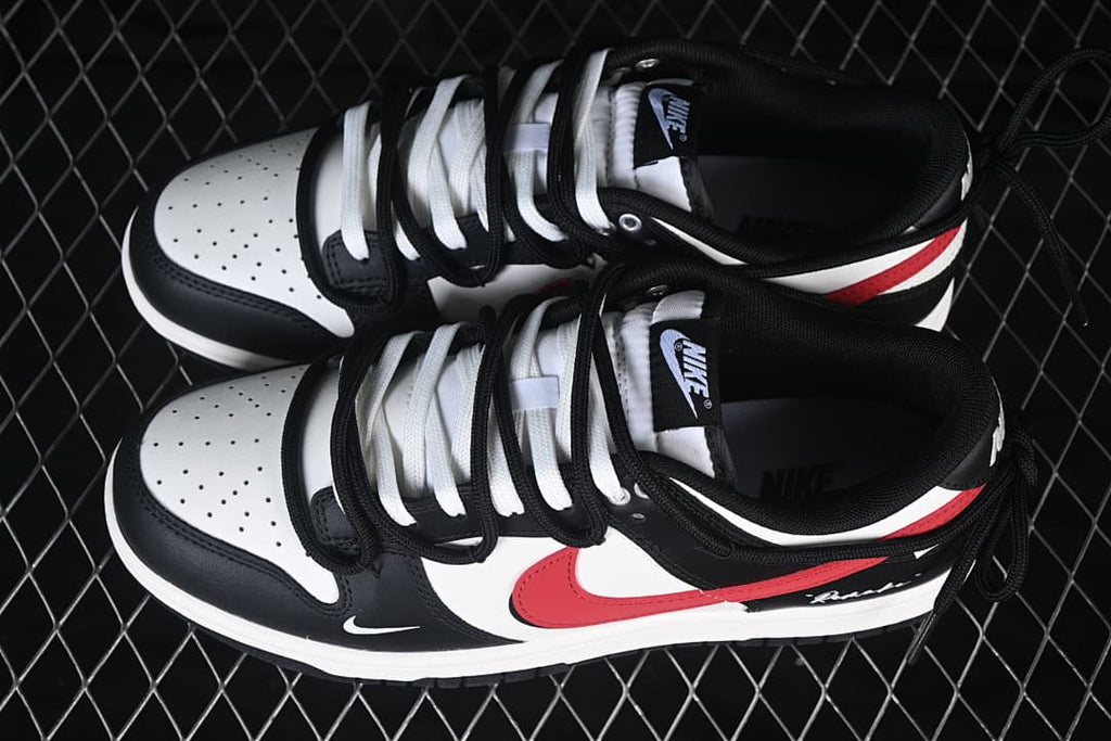 Top view of black, white, and red Nike SB Dunk Low sneakers with contrasting laces and strap details.