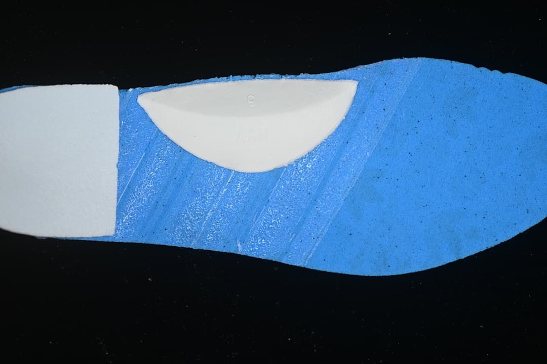 Blue shoe insole detail with a small embossed size marking