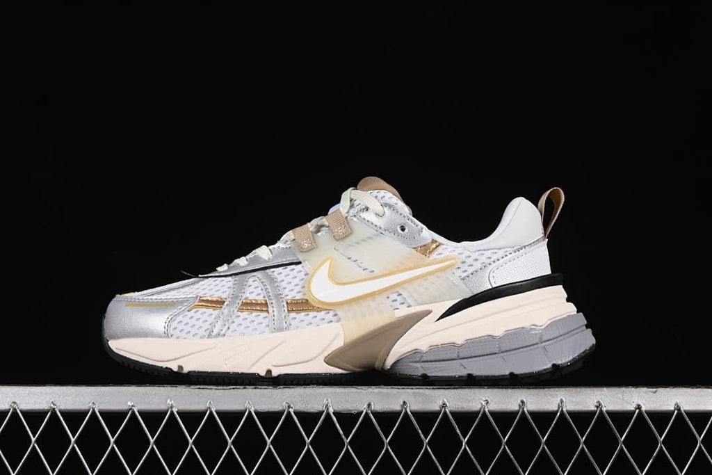 Side view of the Nike V2K Run in gray, white, silver and tan-gold.