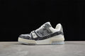 Side profile of a gray patterned Louis Vuitton Trainer-style sneaker with white and cream details.