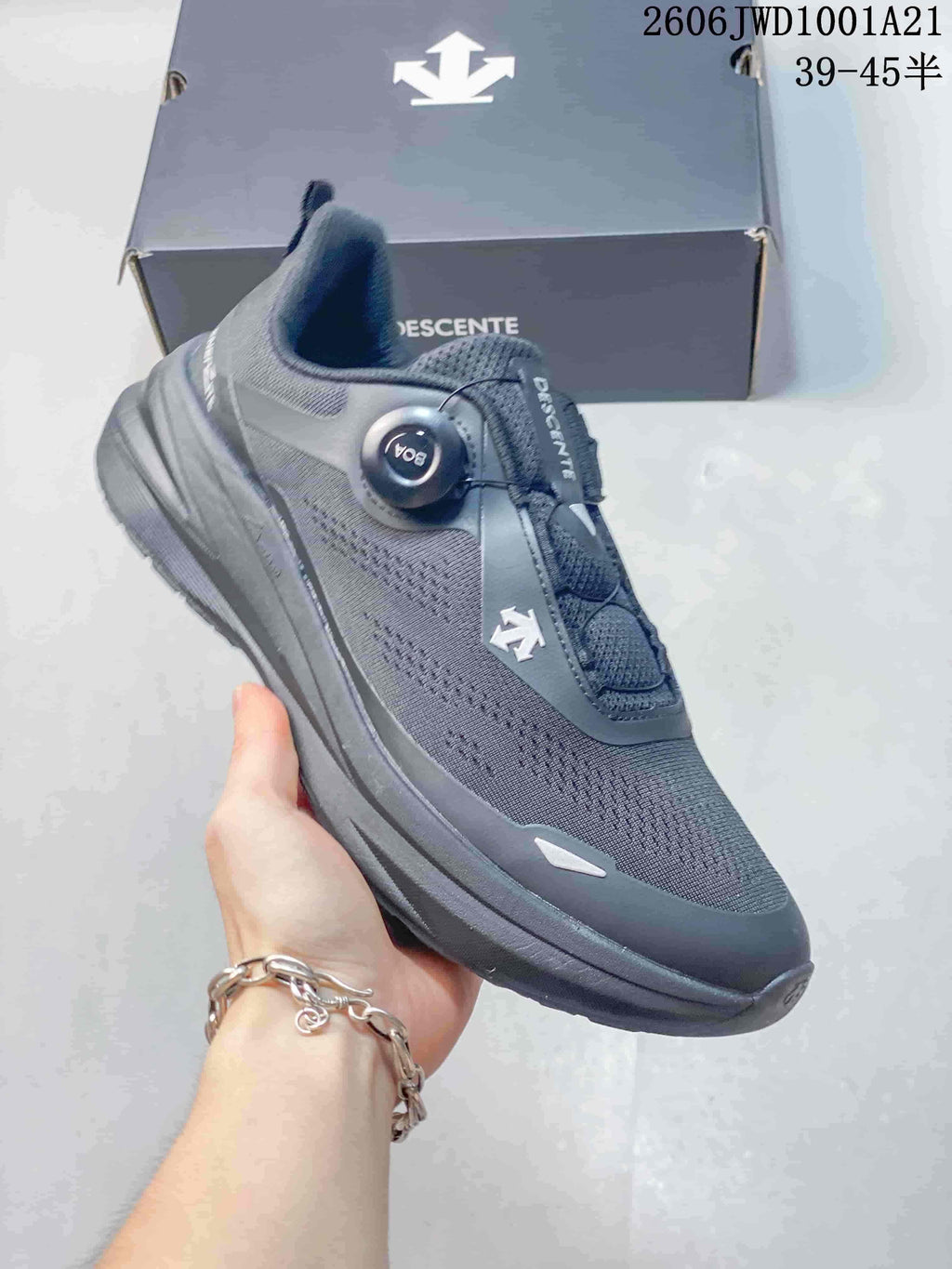 Close view of a gray DESCENTE sneaker showing its mesh-style upper, dial closure, and sole.