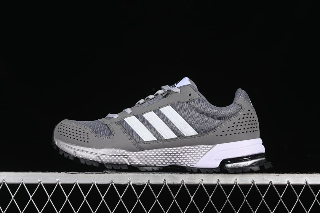 Side view of the gray sneaker with white stripes and textured outsole
