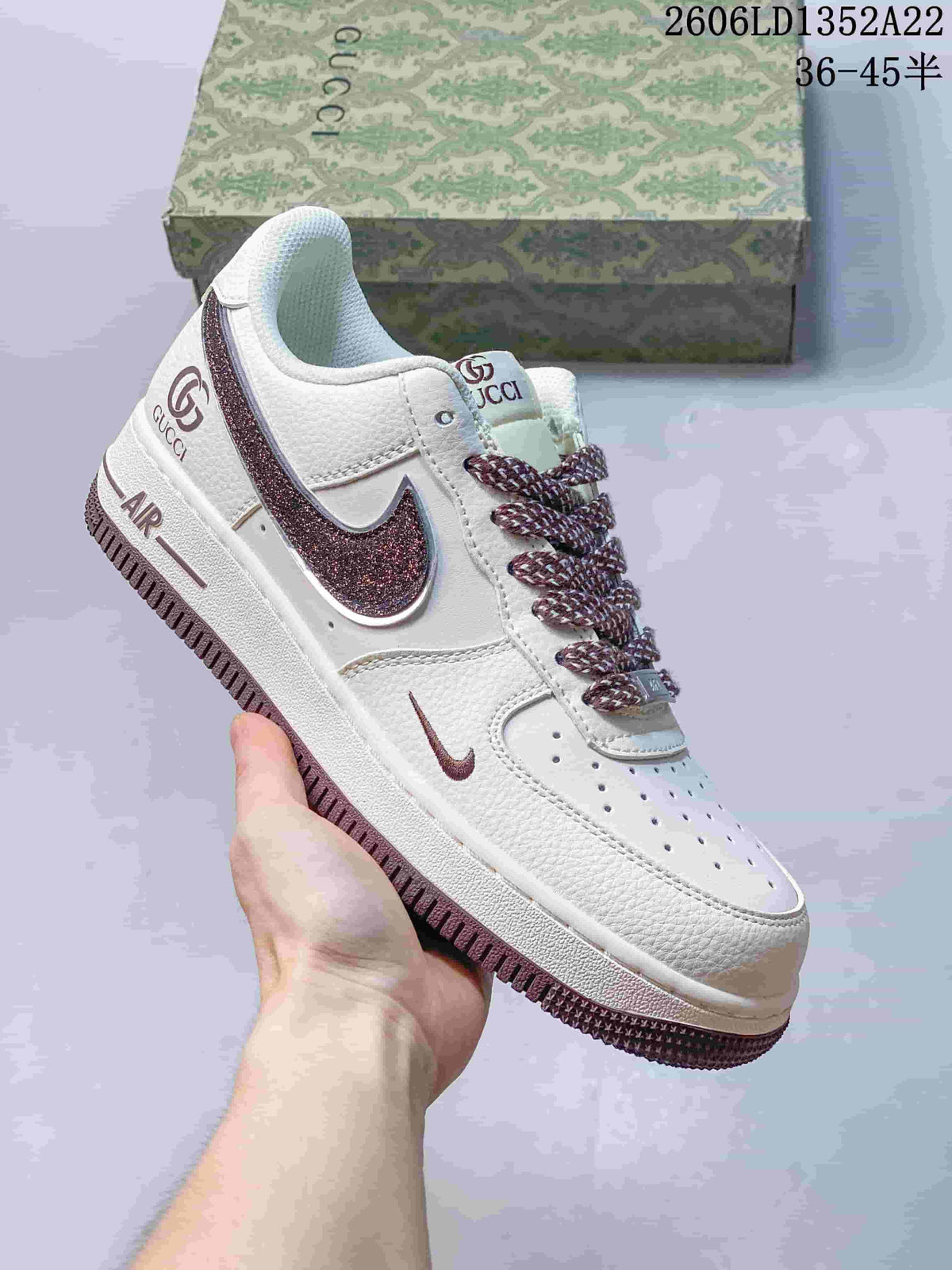 White low-top sneaker with mauve accents, patterned laces and glitter-effect Swoosh.