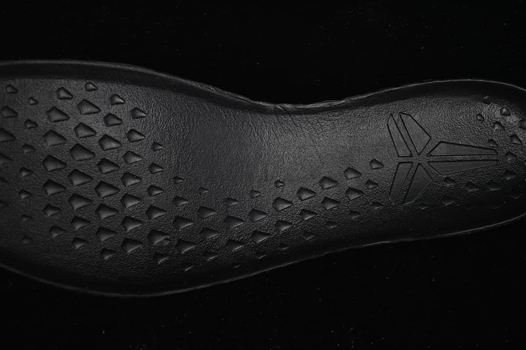 Close-up of black outsole traction pattern and emblem
