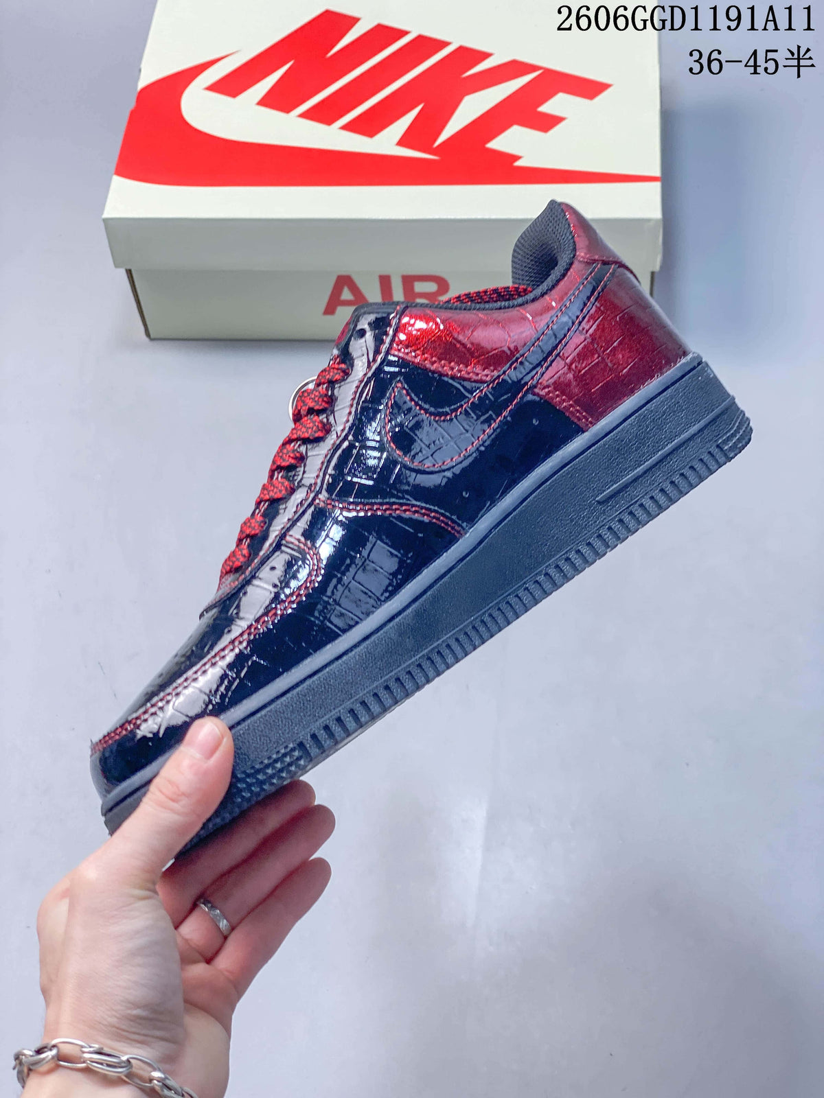 Side profile of a glossy dark sneaker with burgundy panels and contrast stitching