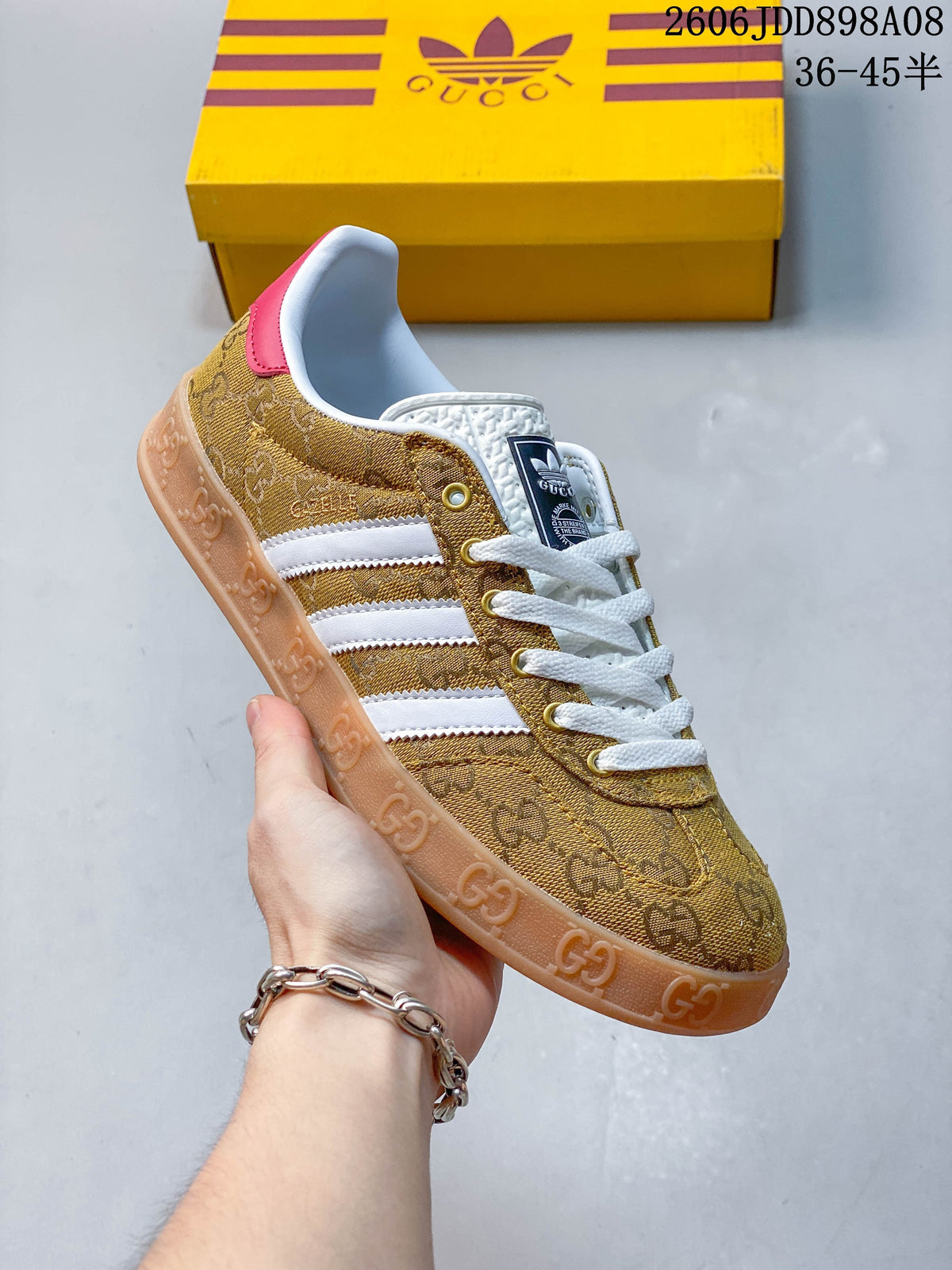 Side view of a gold patterned sneaker with white stripes and white laces