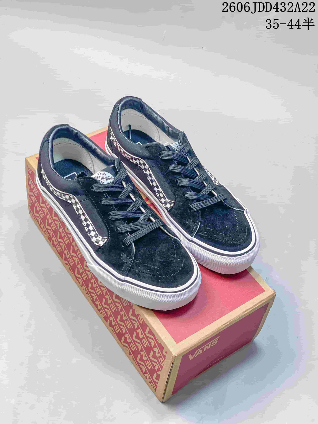 Pair of black Vans SK8-Low sneakers with checkerboard side stripes and white soles