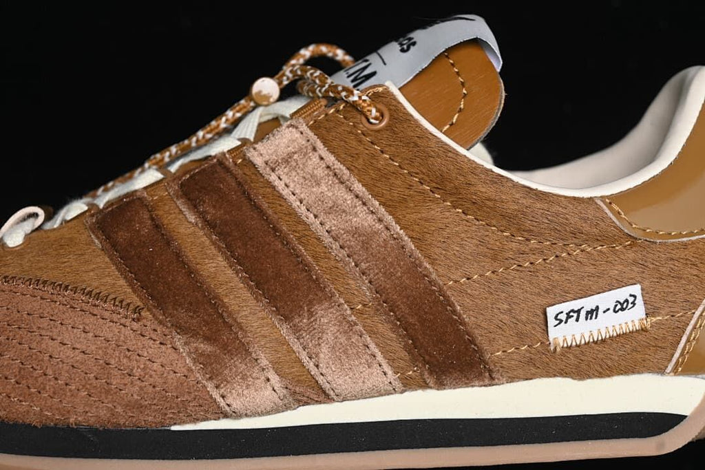 Close-up of textured brown upper, layered stripes and side label
