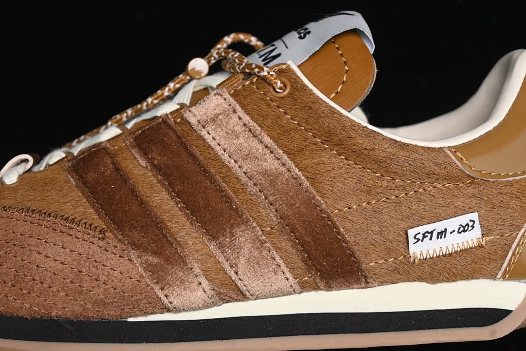 Close-up of textured brown upper, layered stripes and side label