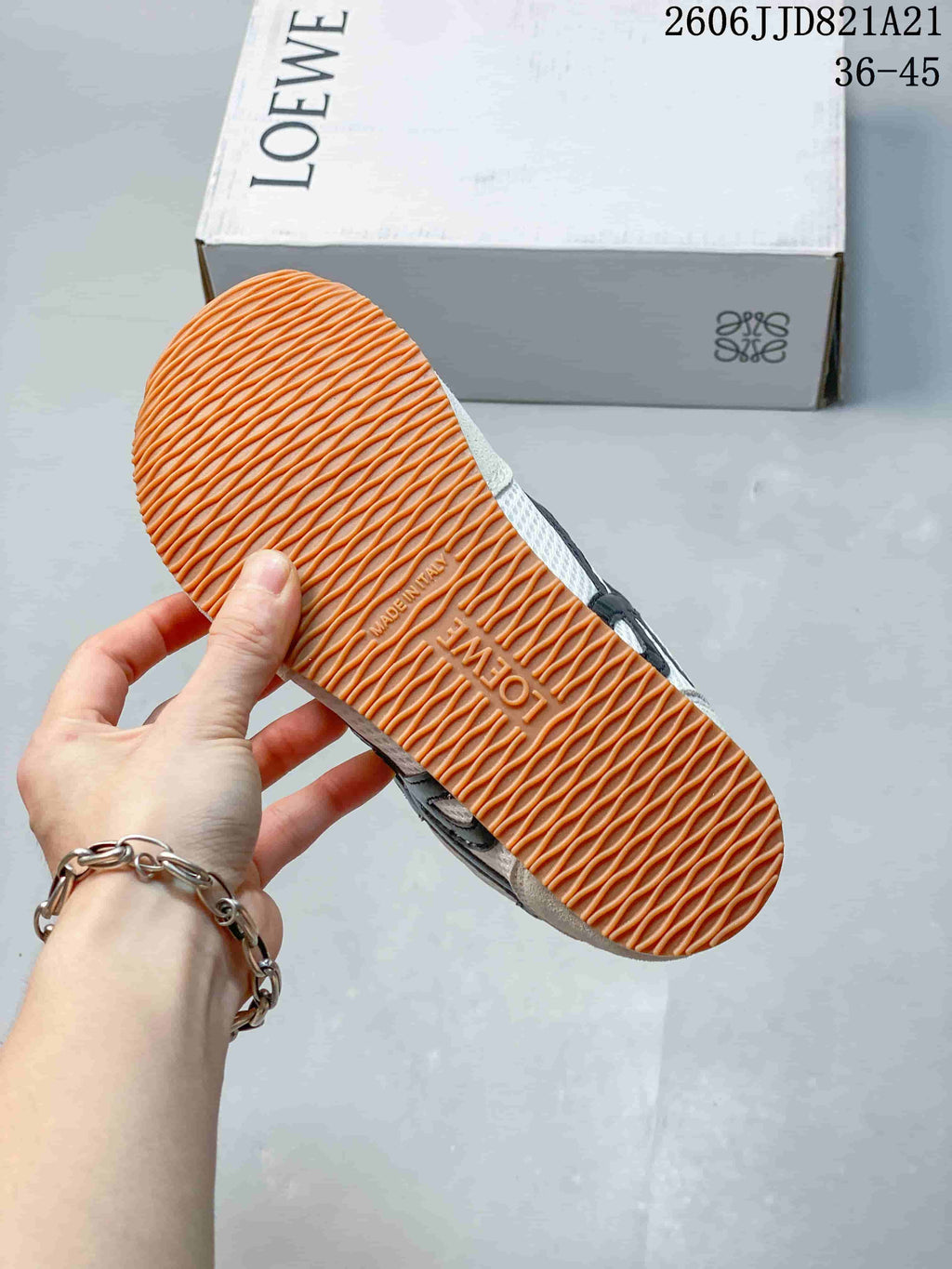 Underside of a Loewe sneaker showing a gum-colored outsole with wavy tread.