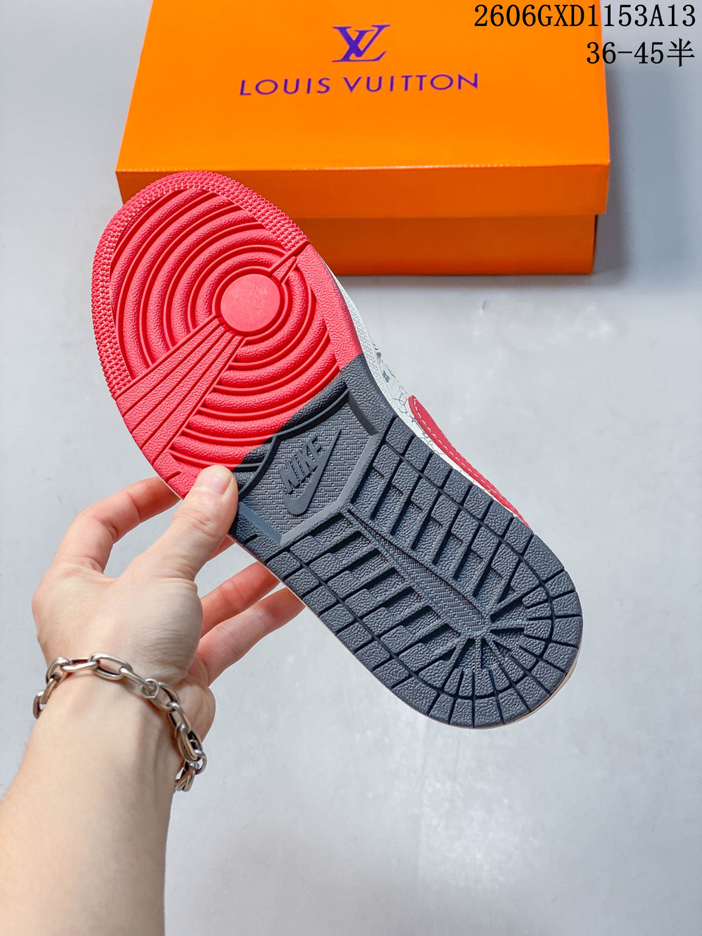 Underside of the sneaker showing a red and dark gray outsole