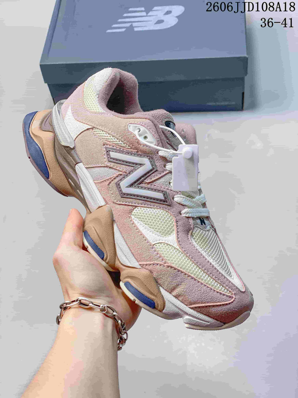Angled side view of a pink and cream New Balance 9060 sneaker