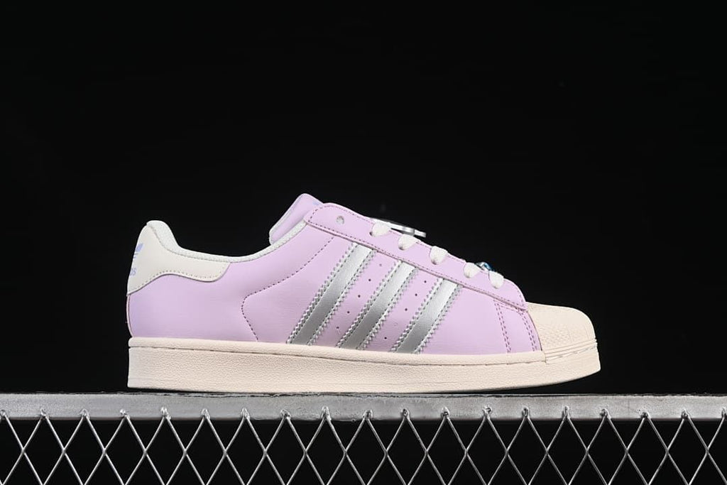 Side profile showing silver stripes and lilac-pink upper