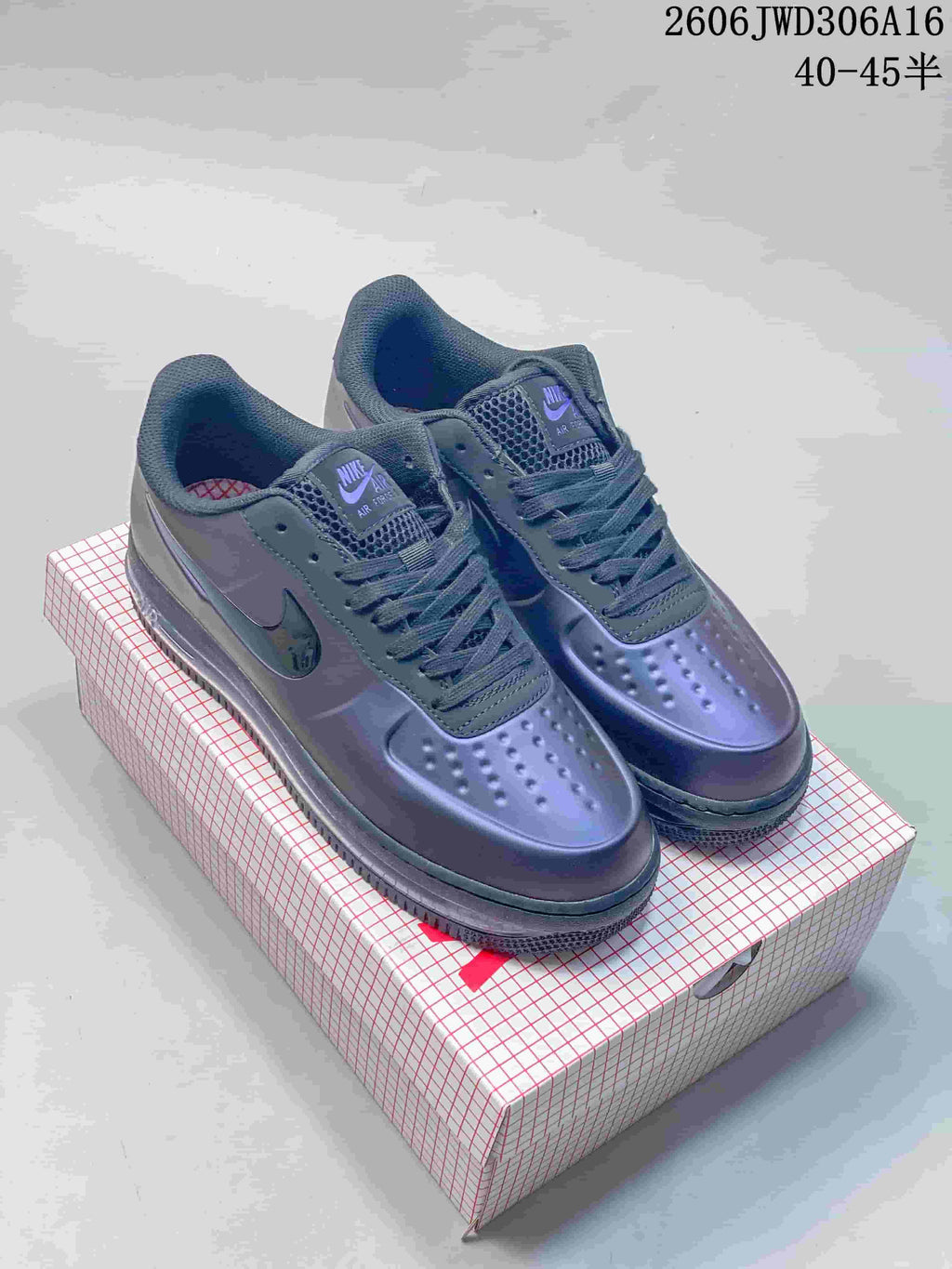 Pair of glossy purple Nike Air Force 1 low-top sneakers on a patterned box