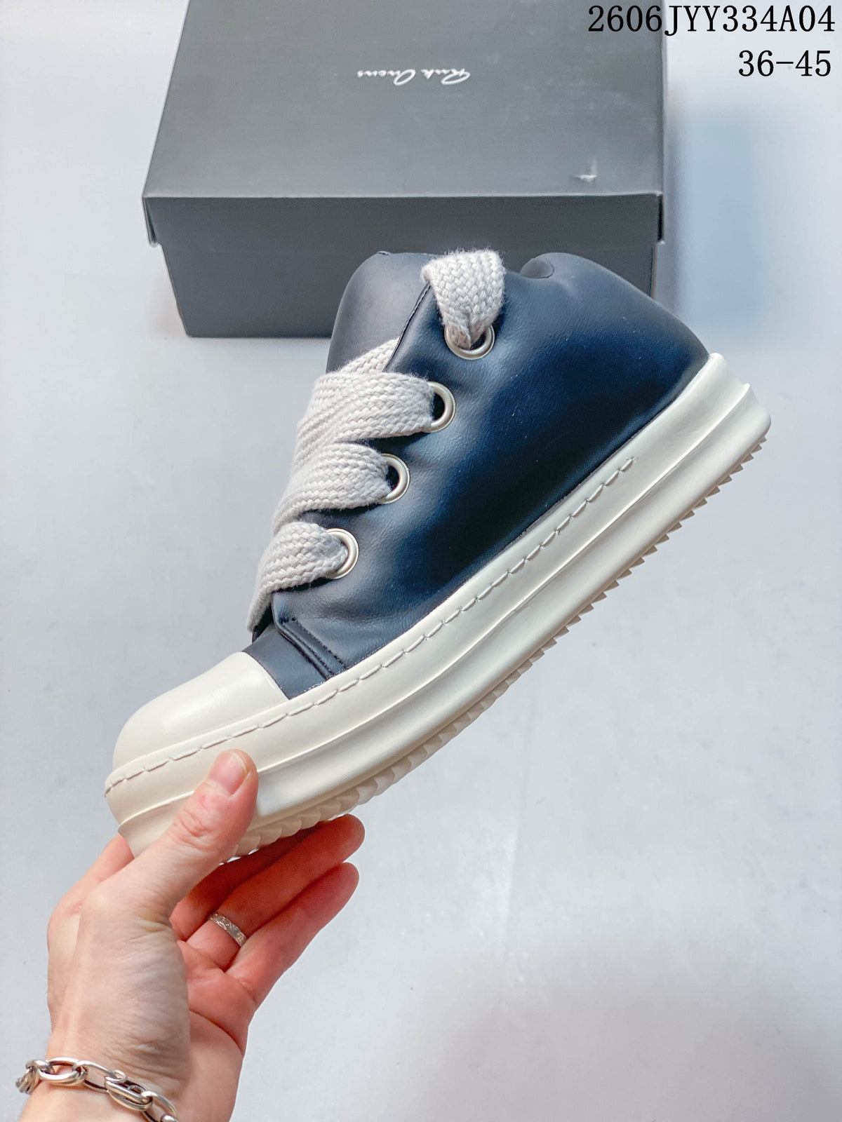 Side view showing the navy upper, oversized laces, ivory toe cap, and stitched sole