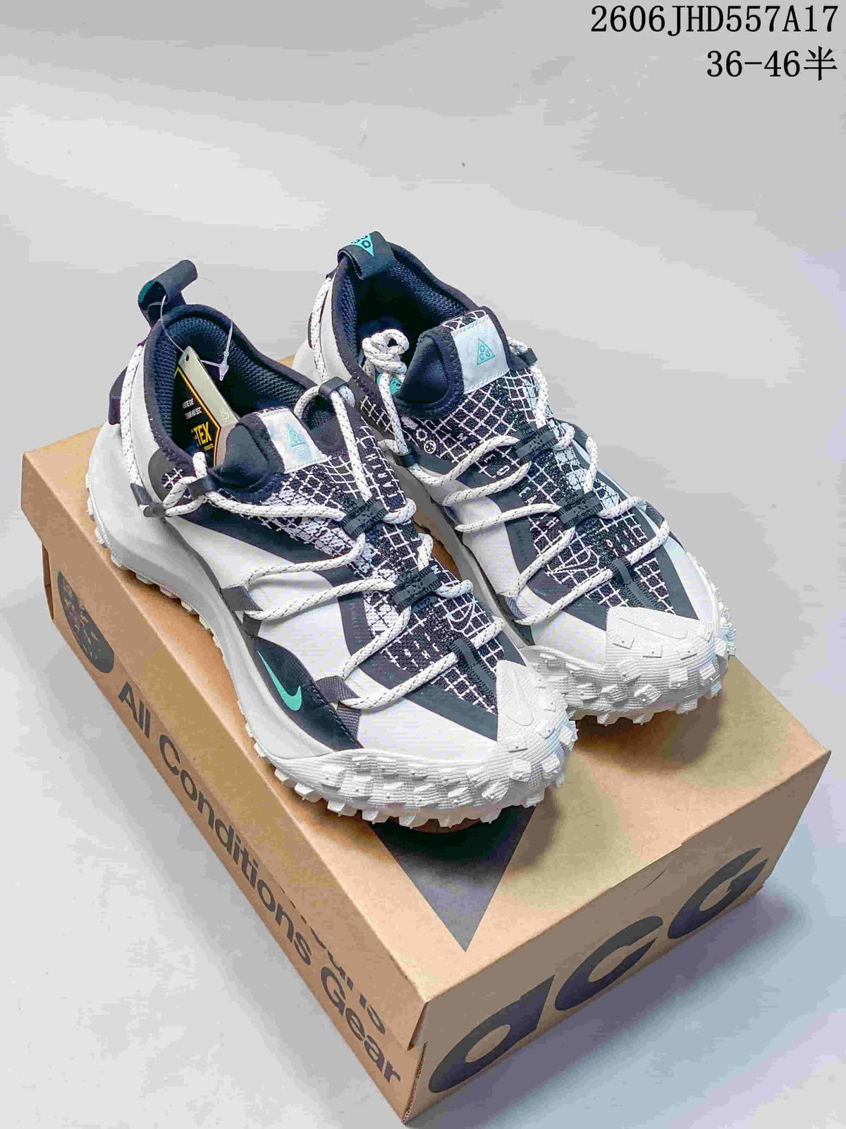 Pair of white, black, and aqua Nike ACG Mountain Fly sneakers on a box
