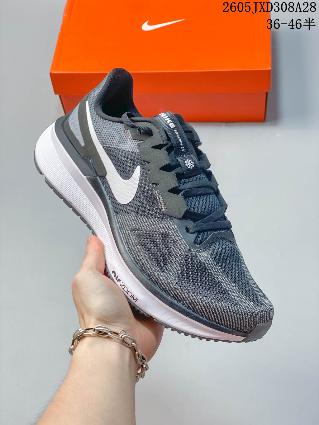 Angled side view of a gray Nike running shoe with white side logo and white midsole.